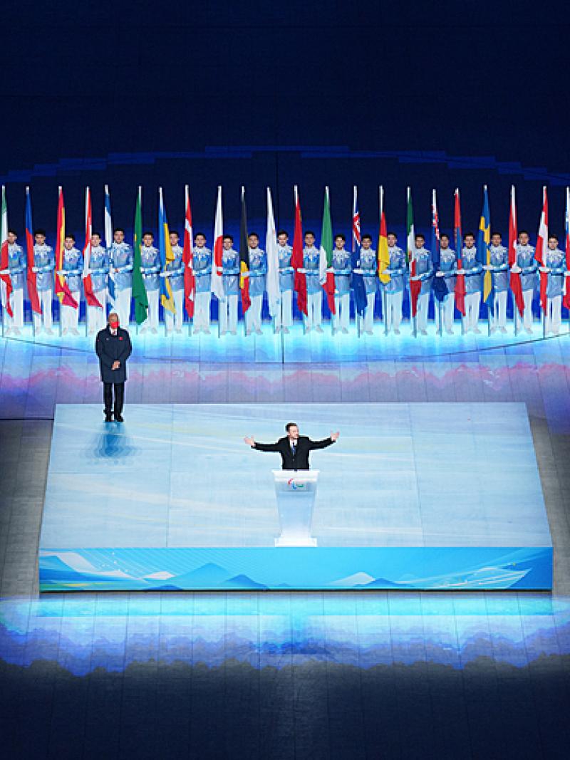 Andrew Parsons is pictured with his arms wide open while speaking during the closing ceremony of Beijing 2022